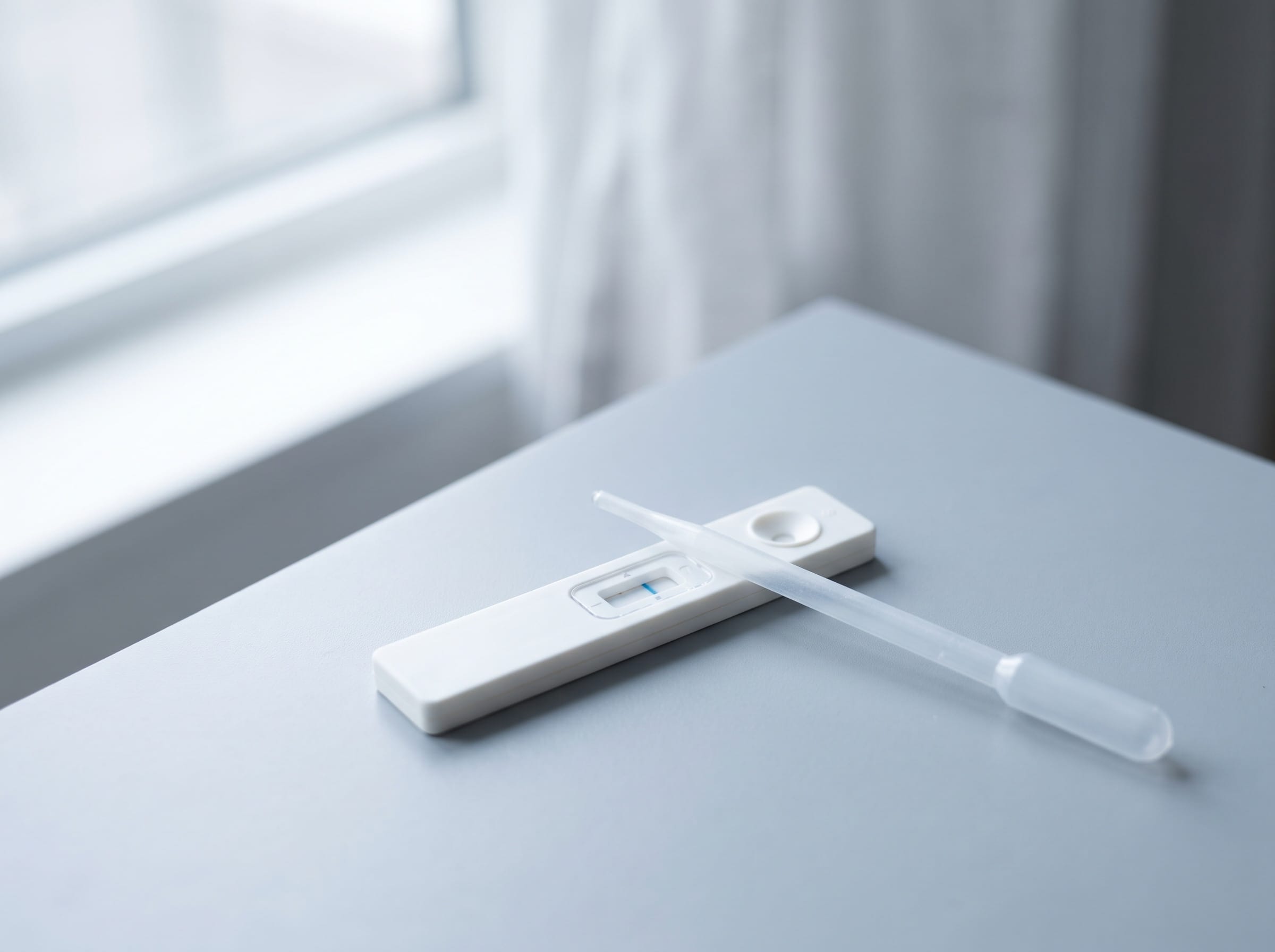 An at-home hormone test cassette with a dropper resting across it